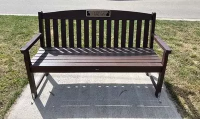 Image of brown memorial bench with plaque